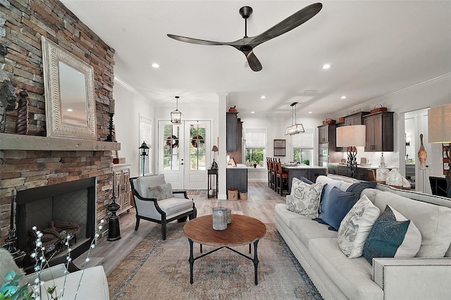 622 W 11th Ave, Mount Dora, FL 32757 - living area with ceiling fan, light wood-style flooring, crown molding, recessed lighting, and a large fireplace