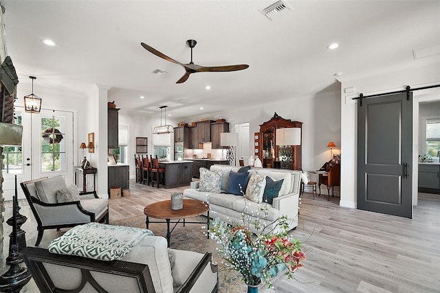 622 W 11th Ave, Mount Dora, FL 32757 - living room with a ceiling fan, a barn door, light wood finished floors, recessed lighting, and ornamental molding