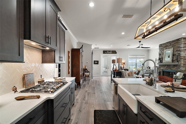 622 W 11th Ave, Mount Dora, FL 32757 - kitchen with stainless steel appliances, open floor plan, backsplash, light wood-type flooring, and decorative light fixtures