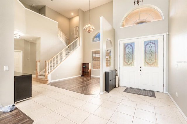 4548 Barrister Dr, Clermont, FL 34711 - entrance foyer featuring a towering ceiling, stairs, a chandelier, light tile patterned floors, and healthy amount of natural light