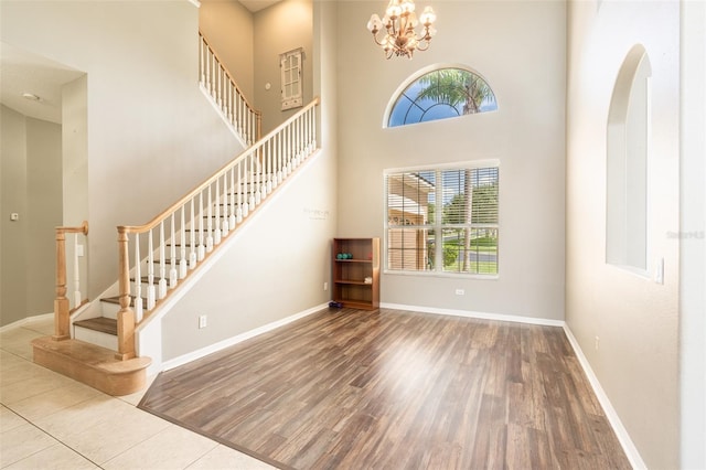 4548 Barrister Dr, Clermont, FL 34711 - unfurnished living room with stairway, a high ceiling, wood finished floors, arched walkways, and a chandelier