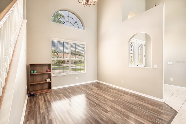 4548 Barrister Dr, Clermont, FL 34711 - foyer featuring wood finished floors, healthy amount of natural light, a towering ceiling, a chandelier, and arched walkways