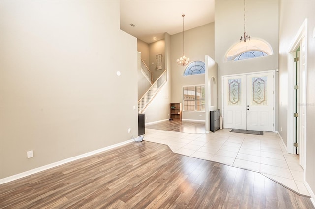 4548 Barrister Dr, Clermont, FL 34711 - foyer entrance with a chandelier, stairway, light wood-type flooring, and a high ceiling