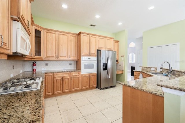 4548 Barrister Dr, Clermont, FL 34711 - kitchen featuring white appliances, tasteful backsplash, light stone countertops, glass insert cabinets, and recessed lighting
