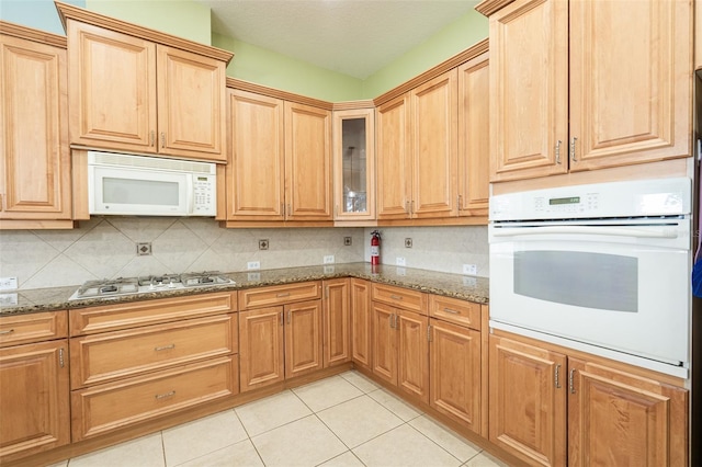 4548 Barrister Dr, Clermont, FL 34711 - kitchen featuring white appliances, light tile patterned flooring, backsplash, glass insert cabinets, and stone countertops