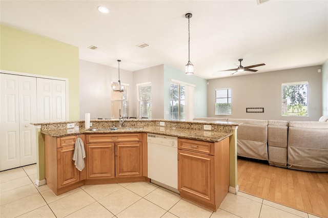 4548 Barrister Dr, Clermont, FL 34711 - kitchen with white dishwasher, open floor plan, ceiling fan, light stone countertops, and light tile patterned floors