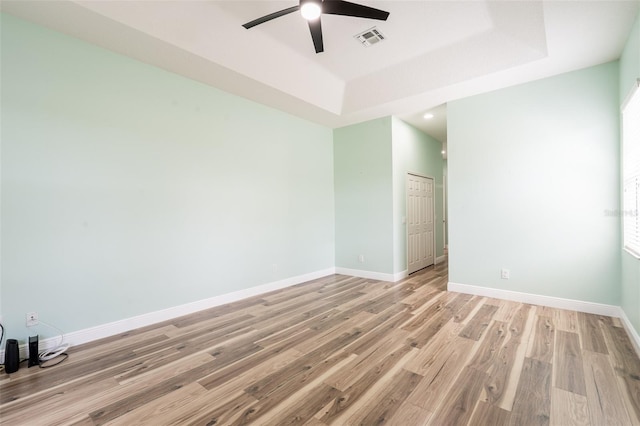 4548 Barrister Dr, Clermont, FL 34711 - empty room featuring ceiling fan, light wood finished floors, a tray ceiling, and recessed lighting