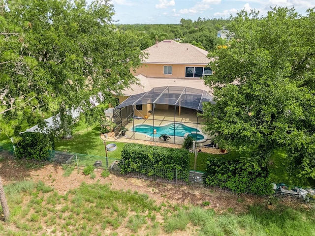 4548 Barrister Dr, Clermont, FL 34711 - rear view of property featuring a fenced backyard, a patio, glass enclosure, and a pool with connected hot tub