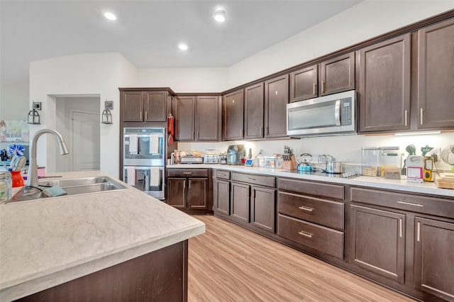 2488 Begonia St, Mascotte, FL 34753 - kitchen featuring appliances with stainless steel finishes, light wood finished floors, light countertops, dark brown cabinetry, and recessed lighting