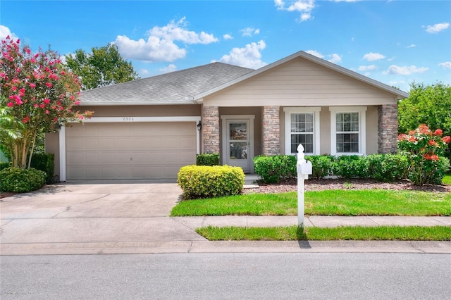 6906 Glenbrook Dr, Lakeland, FL 33811 - view of front of house featuring a garage, stone siding, and concrete driveway