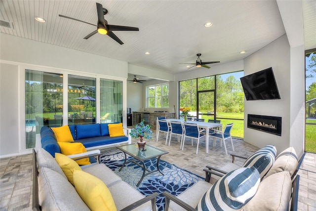 1702 Hidden Palms Dr, Davenport, FL 33897 - sunroom / solarium featuring outdoor dining area, an outdoor living space with a fireplace, ceiling fan, and exterior kitchen