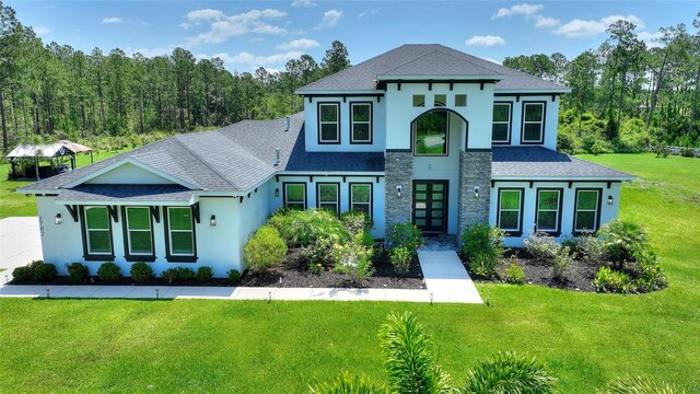 1702 Hidden Palms Dr, Davenport, FL 33897 - view of front of house featuring roof with shingles, a front lawn, and stucco siding