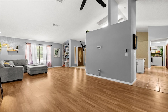 3184 Maltby Dr, Deltona, FL 32738 - living area with a ceiling fan, independent washer and dryer, light wood finished floors, and vaulted ceiling