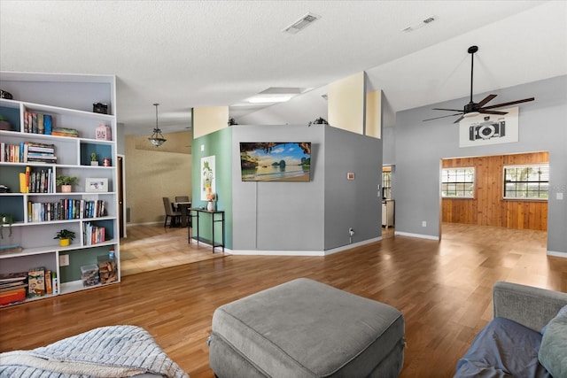 3184 Maltby Dr, Deltona, FL 32738 - living room with ceiling fan, wood finished floors, high vaulted ceiling, and wood walls