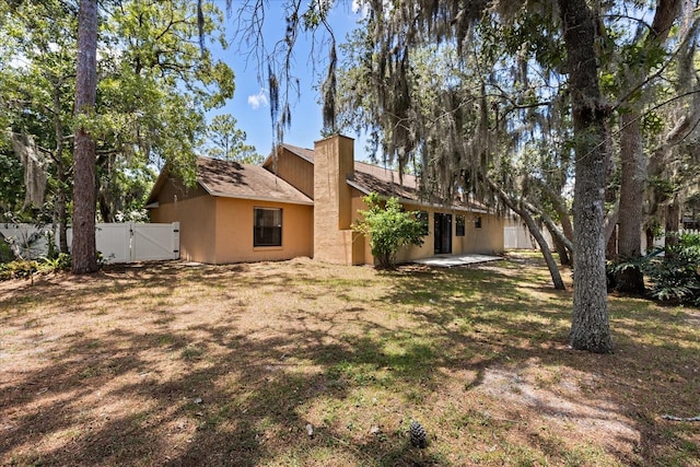 3184 Maltby Dr, Deltona, FL 32738 - rear view of property with a gate and a chimney