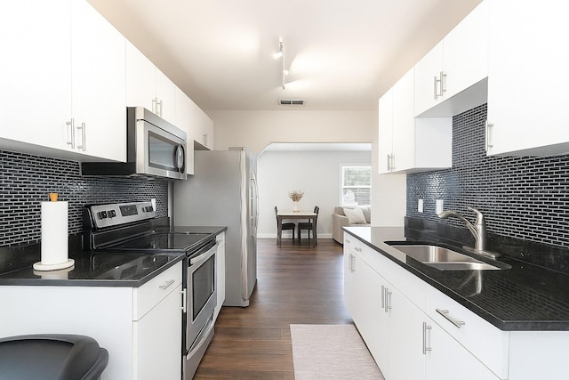 999 W Juniata St, Clermont, FL 34711 - kitchen featuring stainless steel appliances, decorative backsplash, dark wood-style flooring, and dark countertops