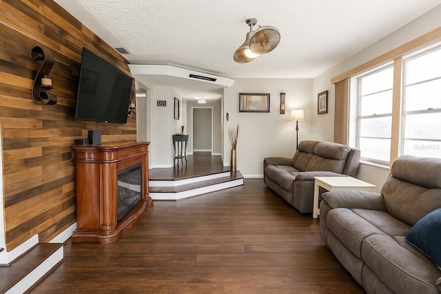 999 W Juniata St, Clermont, FL 34711 - living room featuring dark wood-style flooring, a textured ceiling, and a glass covered fireplace