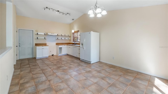 15925 Summit Ct, Clermont, FL 34711 - kitchen with white appliances, open shelves, a chandelier, track lighting, and white cabinets