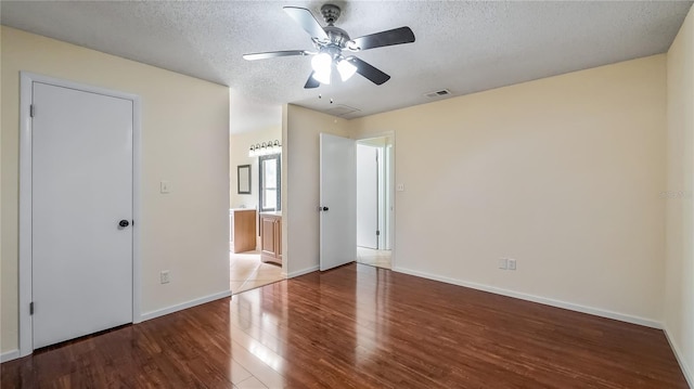 15925 Summit Ct, Clermont, FL 34711 - unfurnished bedroom with wood finished floors, a textured ceiling, connected bathroom, and a ceiling fan