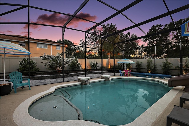 318 Stone Castle Loop, Lady Lake, FL 32159 - pool at dusk featuring a water slide, a patio area, a fenced backyard, and a lanai
