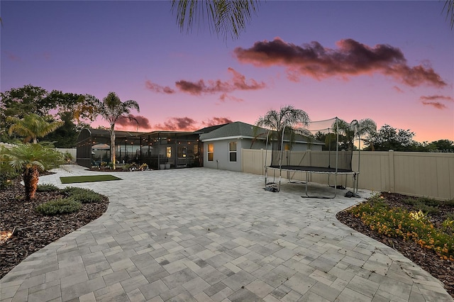 318 Stone Castle Loop, Lady Lake, FL 32159 - view of front of house featuring a trampoline, a fenced backyard, and a patio area