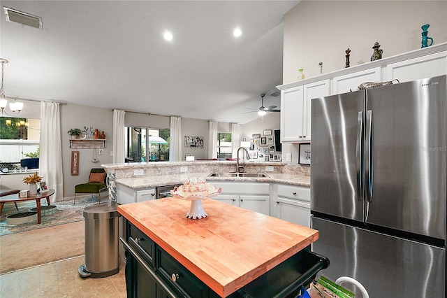 318 Stone Castle Loop, Lady Lake, FL 32159 - kitchen with freestanding refrigerator, wooden counters, white cabinetry, a peninsula, and a ceiling fan