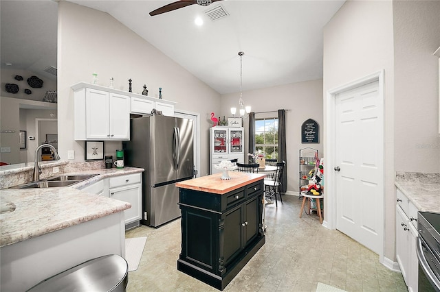 318 Stone Castle Loop, Lady Lake, FL 32159 - kitchen with wooden counters, freestanding refrigerator, white cabinetry, ceiling fan, and pendant lighting