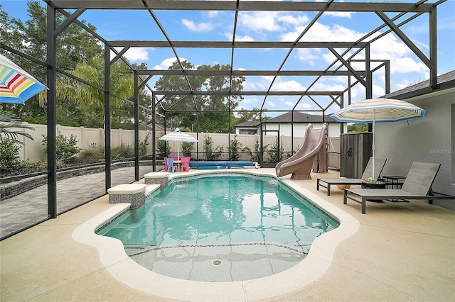 318 Stone Castle Loop, Lady Lake, FL 32159 - view of swimming pool with a water slide, a patio, a fenced backyard, and a lanai