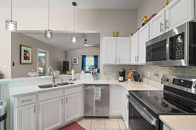 4300 Leafway Cir, Leesburg, FL 34748 - kitchen with appliances with stainless steel finishes, a peninsula, tasteful backsplash, white cabinetry, and lofted ceiling