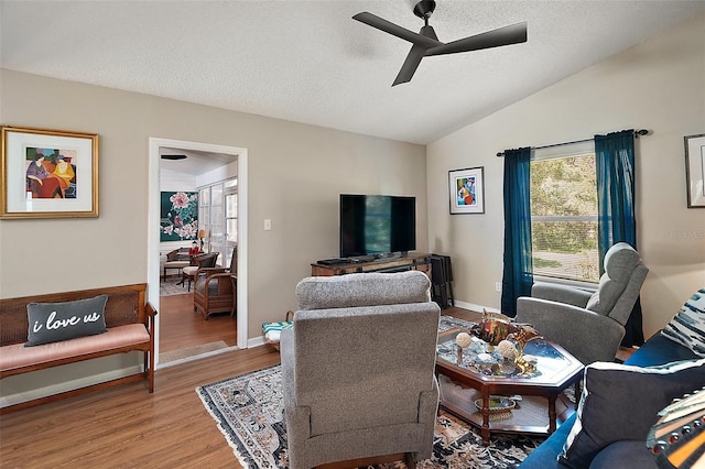 4300 Leafway Cir, Leesburg, FL 34748 - living area with light wood-style flooring, vaulted ceiling, ceiling fan, and a textured ceiling