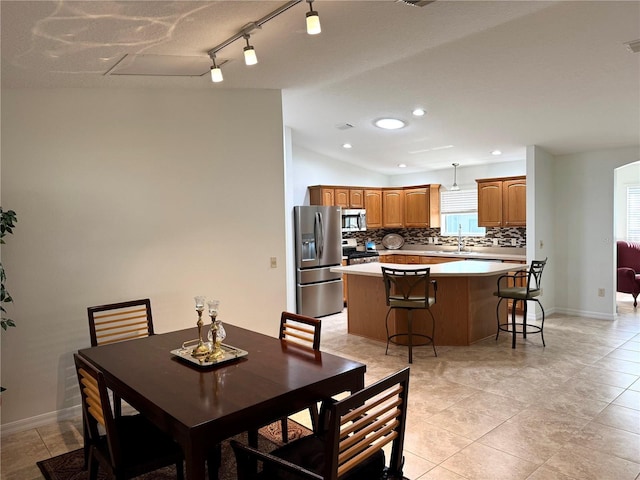 17483 SE 74th Netherclift Ter, The Villages, FL 32162 - dining area featuring rail lighting, recessed lighting, vaulted ceiling, and light tile patterned floors