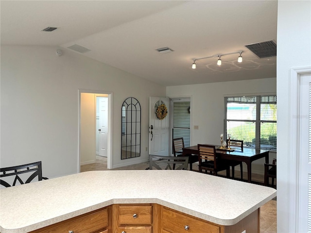 17483 SE 74th Netherclift Ter, The Villages, FL 32162 - kitchen featuring light countertops, vaulted ceiling, and brown cabinets