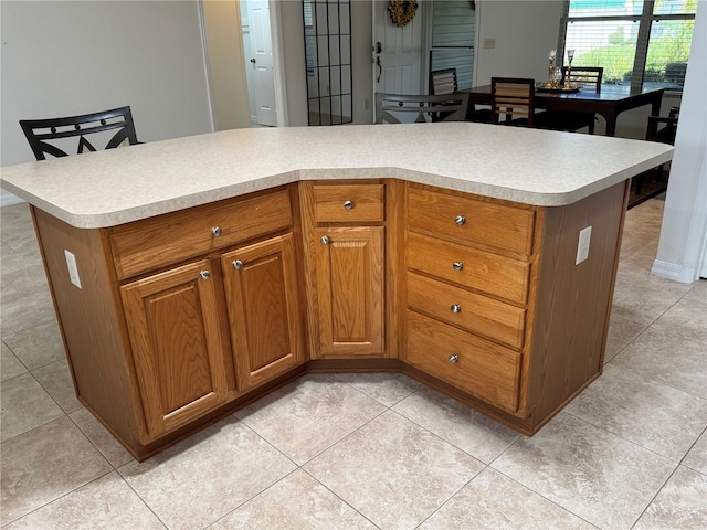 17483 SE 74th Netherclift Ter, The Villages, FL 32162 - kitchen with light countertops, brown cabinets, and light tile patterned flooring