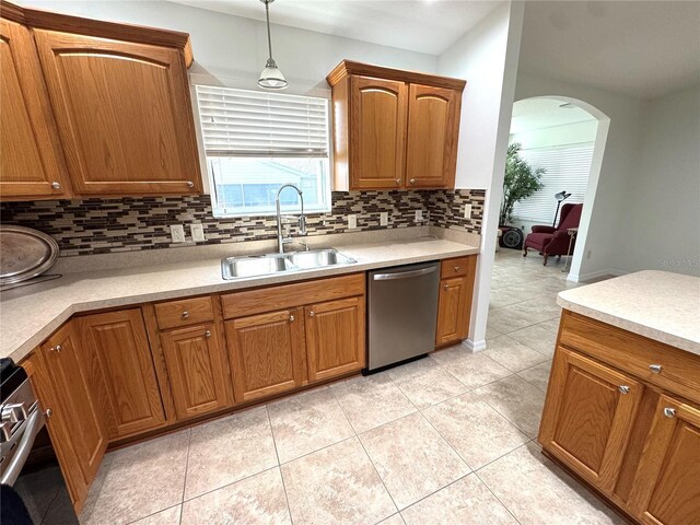 17483 SE 74th Netherclift Ter, The Villages, FL 32162 - kitchen featuring dishwasher, backsplash, hanging light fixtures, light tile patterned floors, and light countertops