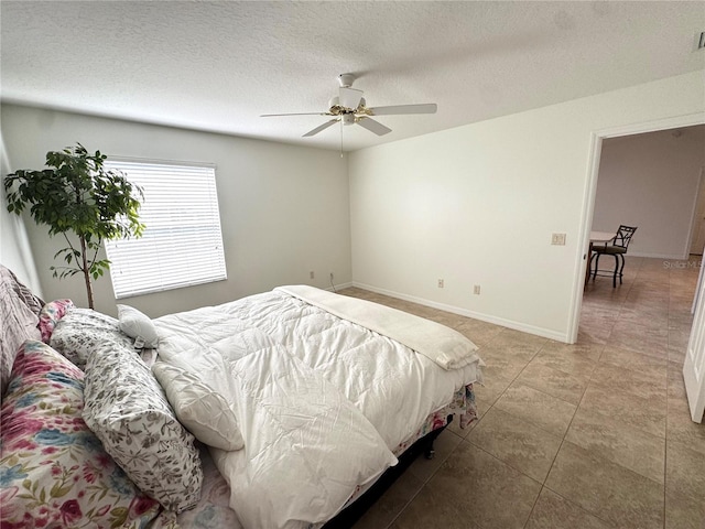 17483 SE 74th Netherclift Ter, The Villages, FL 32162 - bedroom featuring light tile patterned floors, a textured ceiling, and ceiling fan