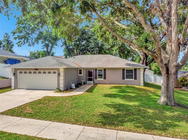 1511 W Magnolia St, Clermont, FL 34711 - ranch-style house with an attached garage, a shingled roof, concrete driveway, and stucco siding