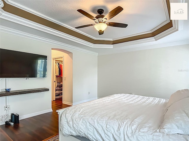 2994 Adrienne Way, The Villages, FL 32163 - bedroom with arched walkways, ornamental molding, wood finished floors, a raised ceiling, and a ceiling fan