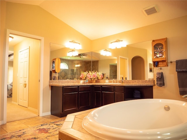 29222 Can Do Ln, Tavares, FL 32778 - bathroom featuring vaulted ceiling, a garden tub, double vanity, and tile patterned floors