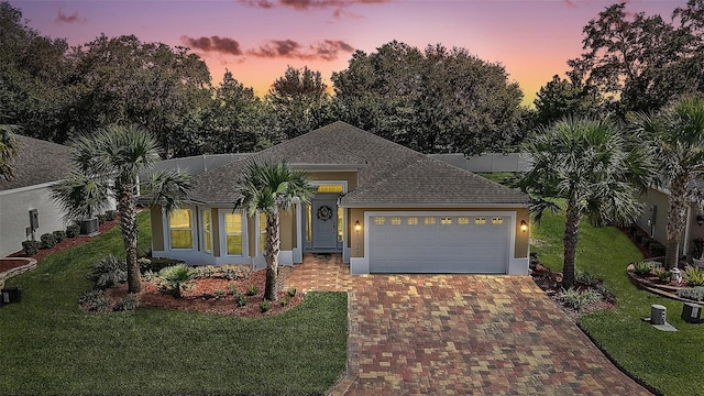 10363 Addison Shore Way, Oxford, FL 34484 - ranch-style home with decorative driveway, an attached garage, a yard, and roof with shingles