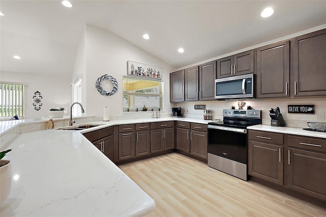 10363 Addison Shore Way, Oxford, FL 34484 - kitchen featuring stainless steel appliances, lofted ceiling, recessed lighting, dark brown cabinets, and light wood finished floors