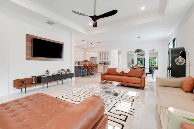 1990 Wallingford Loop, Mount Dora, FL 32757 - living area featuring a raised ceiling, ceiling fan, recessed lighting, light tile patterned flooring, and arched walkways