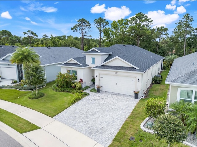 1990 Wallingford Loop, Mount Dora, FL 32757 - view of front of property with an attached garage, decorative driveway, a front lawn, stucco siding, and roof with shingles