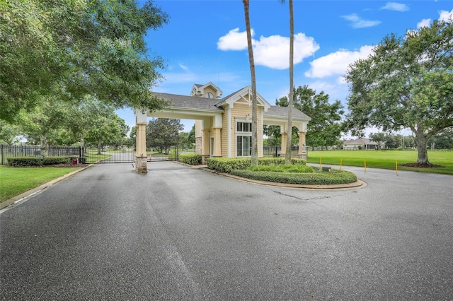 1990 Wallingford Loop, Mount Dora, FL 32757 - view of asphalt street with a gate, a gated entry, and curbs