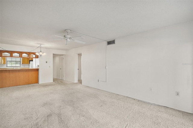 101 N Grandview St Unit 103, Mount Dora, FL 32757 - unfurnished living room featuring a ceiling fan, a chandelier, and light colored carpet