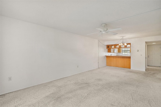 101 N Grandview St Unit 103, Mount Dora, FL 32757 - unfurnished living room featuring a chandelier, light colored carpet, and ceiling fan