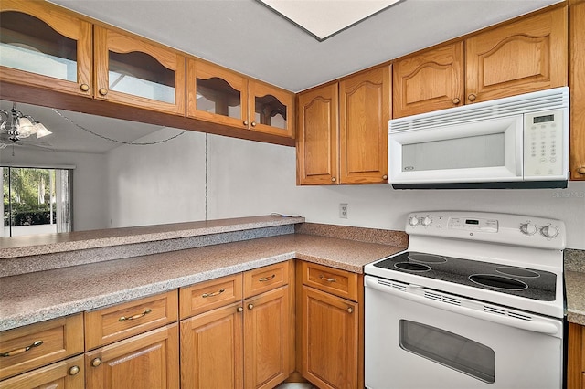 101 N Grandview St Unit 103, Mount Dora, FL 32757 - kitchen featuring white appliances, brown cabinetry, and glass insert cabinets