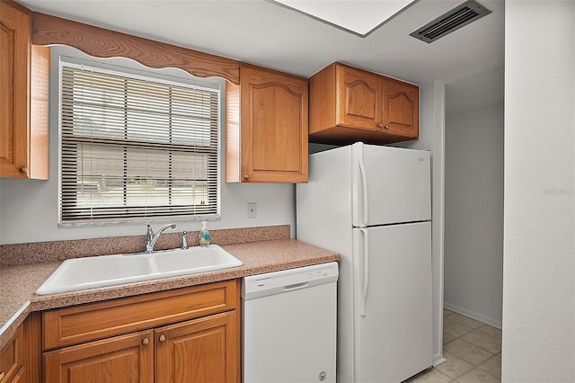 101 N Grandview St Unit 103, Mount Dora, FL 32757 - kitchen with white appliances, light tile patterned flooring, brown cabinetry, and light countertops