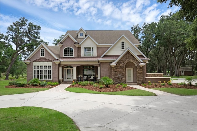 1325 Otters View Ct, Fruitland Park, FL 34731 - view of front of home featuring covered porch, a shingled roof, a standing seam roof, brick siding, and a front lawn