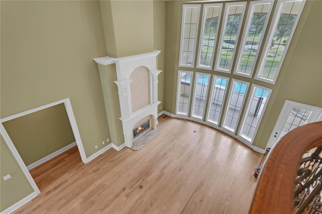 1325 Otters View Ct, Fruitland Park, FL 34731 - living area featuring a towering ceiling, light wood finished floors, and a glass covered fireplace