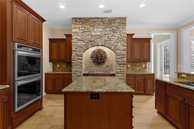 1325 Otters View Ct, Fruitland Park, FL 34731 - kitchen with stainless steel double oven, tasteful backsplash, light wood-style floors, ornamental molding, and light stone countertops